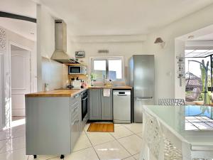 een keuken met een wastafel en een koelkast bij Villa 2 pièces Vue Mer Plage à pied in Le Lavandou
