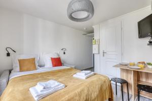 a bedroom with a bed with towels on it at Branded New Cozy Studio in the Heart of Paris 17 in Paris