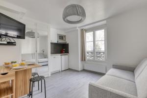 a living room with a couch and a table at Branded New Cozy Studio in the Heart of Paris 17 in Paris