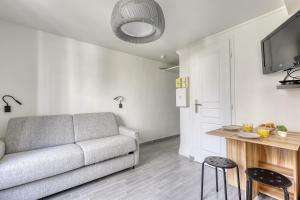 a living room with a couch and a table at Branded New Cozy Studio in the Heart of Paris 17 in Paris