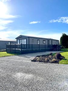 a large building with a fence in front of it at Stones Throw Lodge in Padstow