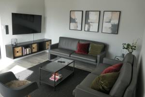sala de estar con sofá y TV en SchönHier, en Westerburg
