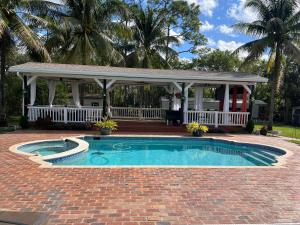 a swimming pool with a gazebo and a house at The Magic Motor Home in Parkland