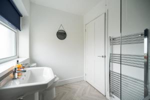 a white bathroom with a sink and a shower at Renvyle House By Horizon Stays in Stockton-on-Tees