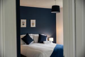 a bedroom with a large white bed with blue walls at Renvyle House By Horizon Stays in Stockton-on-Tees