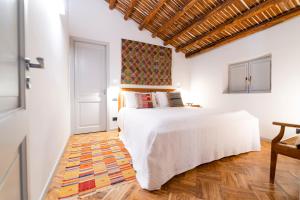Un dormitorio con una cama blanca y suelo de madera. en Palazzo Planeta, en Palermo