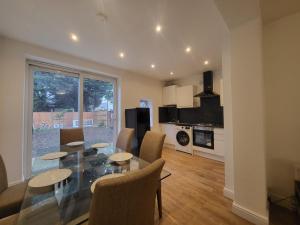 a dining room and living room with a table and chairs at 4 Bedroom House - Free Parking, Great access to London, Herts, Essex in Ponders End +18 photos