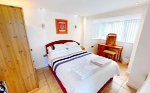 ein Schlafzimmer mit einem großen Bett und einer Holztür in der Unterkunft CROYDE WONKY COTTAGE 1 Bedroom in Croyde