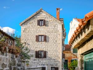 - un vieux bâtiment en pierre avec des fenêtres donnant sur une rue dans l'établissement Apartments F&A, à Split