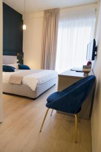 um quarto com uma cama, uma secretária e uma cadeira em Gigi Suites&Apartments em Stresa