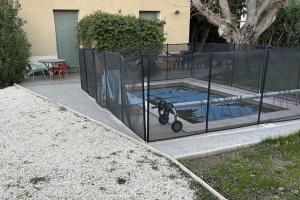 una valla alrededor de una piscina con una bicicleta dentro en Maison de 100 M2 équipée de 4 chambres. en Valence