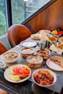 een tafel met borden eten bovenop bij LUXE RESORTS - CENTRALLY HEATED AIR CONDITIONED HOTEL in THE HEART OF KASAULI in Kasauli