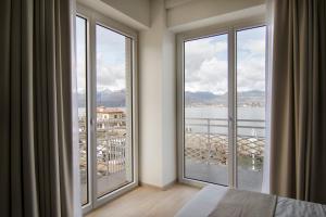 a bedroom with large windows with a view of a city at Gigi Suites&Apartments in Stresa