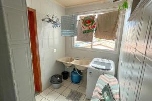a small bathroom with a sink and a washing machine at 3 Quartos da UFU in Uberlândia