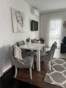 a living room with a white table and chairs at Apartament Glamur in Międzyzdroje