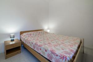 1 dormitorio con cama y mesita de noche de madera en La Conchiglia Patresi - Goelba, en La Guardia