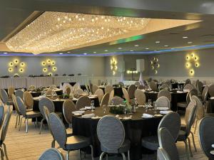 un salón de banquetes con mesas, sillas y luces en Lakeview Golf Resort, en Morgantown