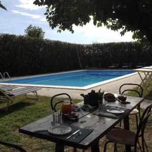 una mesa de picnic con comida junto a una piscina en Residenza Ilde, en Verucchio