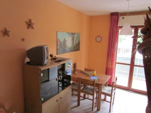 Cette chambre dispose d'un bureau, d'une table et d'une télévision. dans l'établissement Flat in a residence with pools and tennis courts, à Bibione