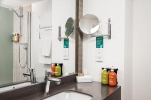 a bathroom with a sink and a mirror at Holiday Inn Haydock by IHG in Haydock