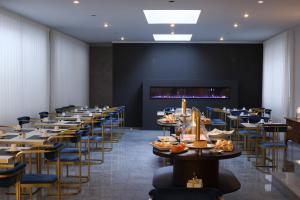un comedor largo con mesas y sillas en Hotel America, en Oporto