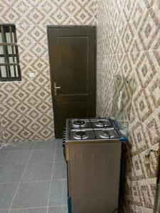 una cucina con piano cottura e una porta in una camera di RESIDENCE KWABO a Cotonou