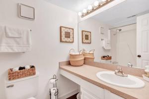 a white bathroom with a sink and a mirror at Modern Designed, Lakefront Home in Garland in Garland +20 photos