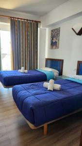 three beds in a room with blue covers on them at Le Mirage Ibiza in San Antonio