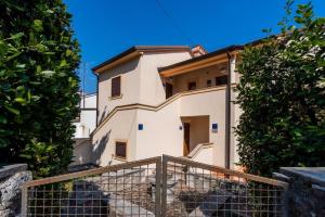 a white house with a fence in front of it at Downtown Apartment Bepi in Opatija