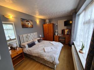 a bedroom with a bed and a desk and window at Beachdene Guest House in Skegness