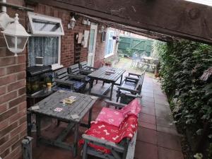un patio al aire libre con mesas y sillas de madera en Beachdene Guest House, en Skegness