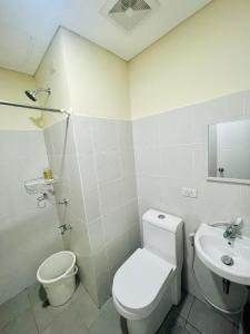 ein weißes Bad mit einem WC und einem Waschbecken in der Unterkunft Northwoods Place in Mandaue City