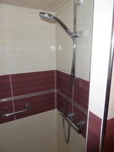 La salle de bains est pourvue d'une douche et de carrelage rouge et blanc. dans l'établissement Maison de vacances St Cyprien Plage, à Saint-Cyprien