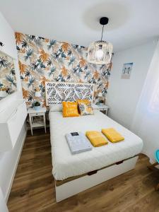a small bedroom with a bed with yellow pillows at APARTAMENTO NUEVO CÉNTRICO en PRIMERA Línea de playa con vistas al Mar, Piscina, aire acondicionado y wifi in Peñíscola +37 photos