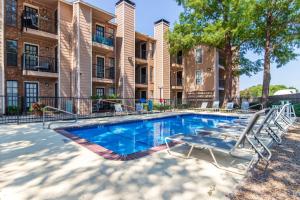 ダラスにあるExtended Stay in DFW One Bedroom Apartmentの建物の前にスイミングプール(ラウンジチェア付)