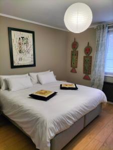 a bedroom with a large white bed with two trays on it at La Mouillère in Verton