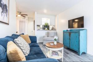 Una sala de estar con un sofá azul y una mesa. en Stay Awhile In This Cozy 1 Bed Apt, en Dallas