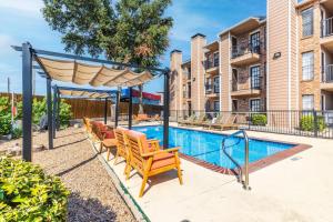 una piscina con sillas y un cenador en Stay Awhile In This Cozy 1 Bed Apt, en Dallas