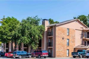 ダラスにあるAffordable Apartment with Balconyの建物前に停車する車両群