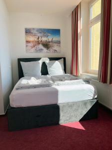 a large bed in a bedroom with a window at Zeitlos Hotel Garni in Scharbeutz