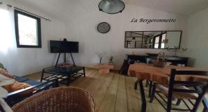een woonkamer met een tafel en een spiegel bij La Bergeronnette in Queyrac