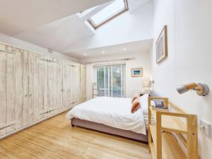 a bedroom with a bed and wooden wardrobes at Primrose Cottage in Emsworth