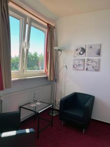 un soggiorno con tavolo, sedia e lampada di Zeitlos Hotel Garni a Scharbeutz