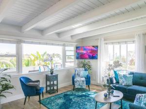 salon z niebieskimi meblami i oknami w obiekcie STUNNINGLY PERFECT Beach ALL NEW REMODEL Galore w mieście Laguna Beach