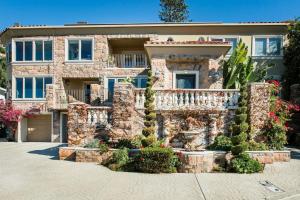 a large stone house with a balcony in front of it at Unparalleled Villa Apartment in an Enchanting Village in Laguna Beach