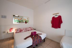 una camera da letto con un letto e una camicia appesa al muro di Le Petit Hotel a Lido di Jesolo