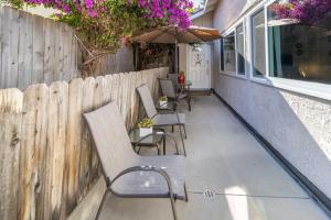 a patio with chairs and an umbrella and a fence at Stunning huge one level 1350 ft. cottage in Mission Viejo