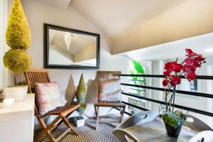 a balcony with chairs and a table and a mirror at Unparalleled Villa Apartment in an Enchanting Village in Laguna Beach