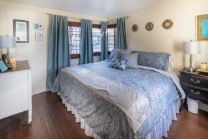 a bedroom with a bed with a blue comforter at MAGICAL COTTAGE DIRECT OCEAN VIEW BEACH W GARAGE, YARD, FIREPLACE in Laguna Beach