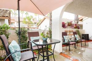 une terrasse avec une table, des chaises et un parasol dans l'établissement Glamorous Regal Design Home with Private Patio and Garage, à Laguna Hills